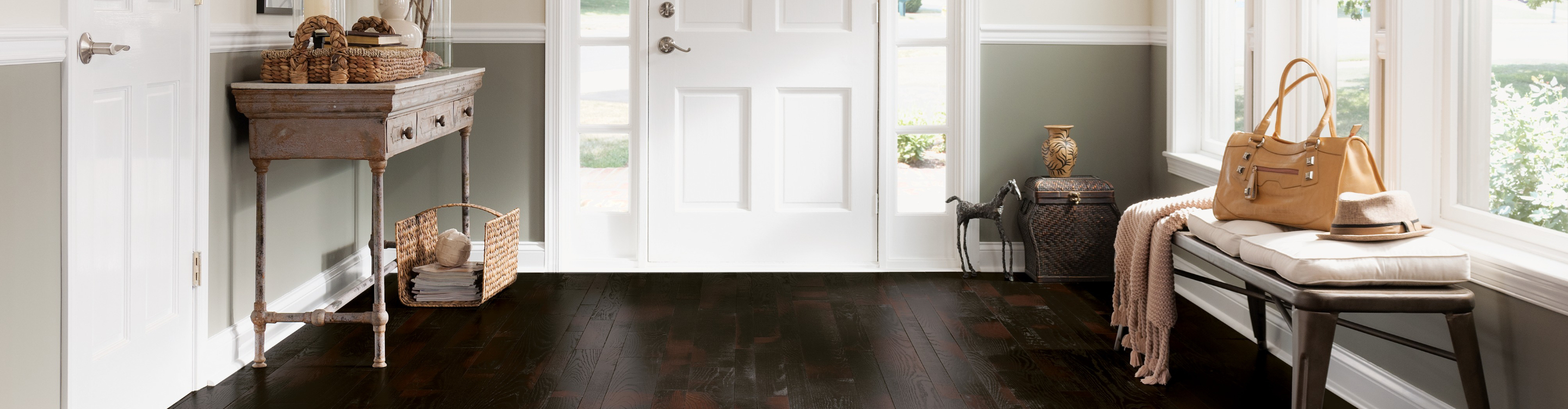 oak burgundy stain hardwood flooring in entryway of home with white front door